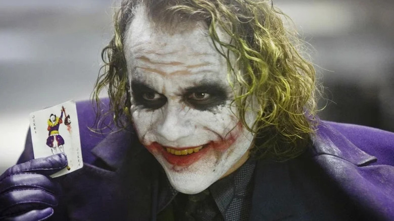 Heath Ledger's Joker holding a playing card in The Dark Knight