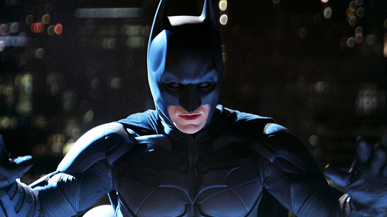 Christian Bale's Batman stands illiminated from below in The Dark Knight