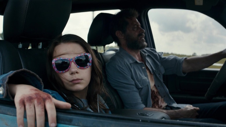 Laura and Logan riding in a trick together in Logan (2017)