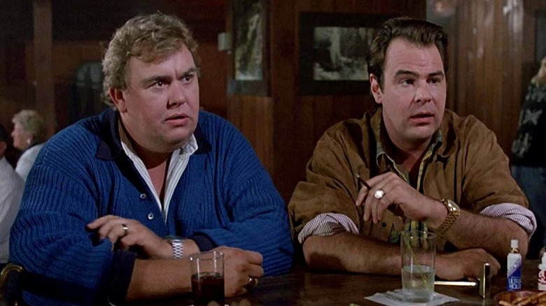 John Candy's Chet Ripley sitting at a bar next to Dan Aykroyd's Roman Craig in The Great Outdoors