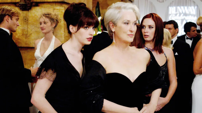 Andy talking to Miranda with Emily in the background in The Devil Wears Prada