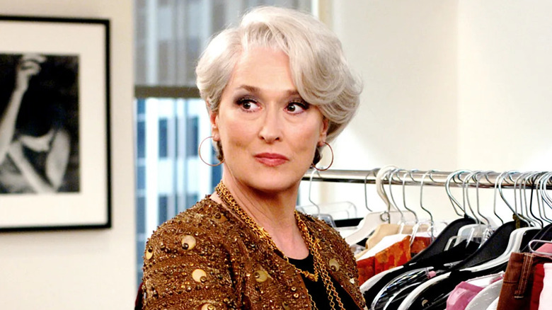 Miranda in front of a clothing rack in The Devil Wears Prada