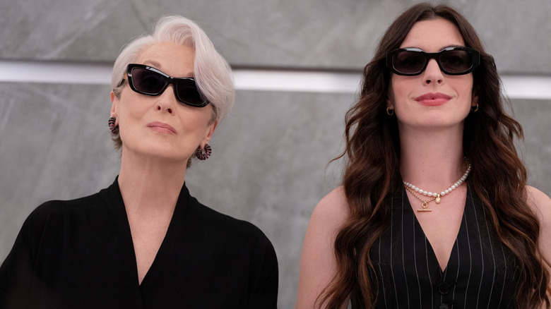 Meryl Streep as Miranda Priestly and Anne Hathaway as Andy Sachs wearing sunglasses and standing next to each other in The Devil Wears Prada 2