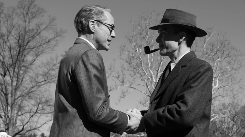 Lewis Strauss and J. Robert Oppenheimer shake hands in a park in "Oppenheimer"