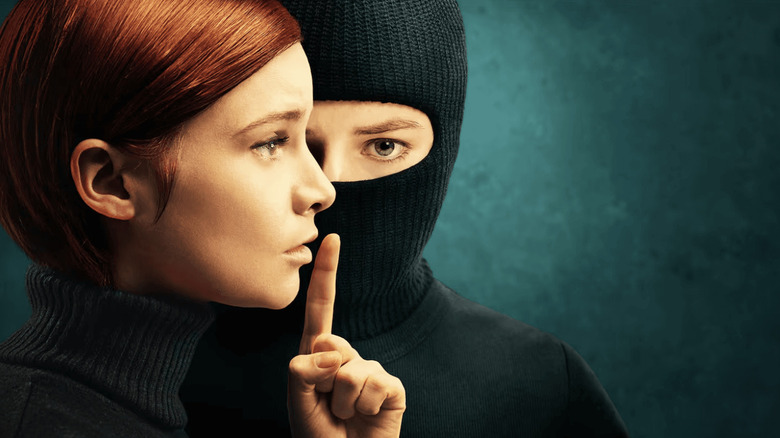 Dolours Price raising her finger next to Marian Price in a ski mask in the Say Nothing poster