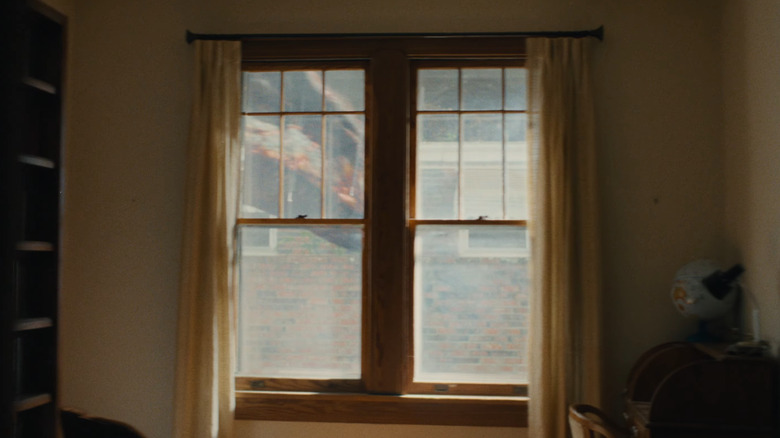 A dinosaur walking by a window in The End of Oak Street