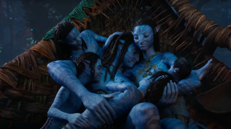 Sam Worthington as Jake Sully lies next to Zoe Saldana as Neytiri and his family in Avatar: The Way of Water