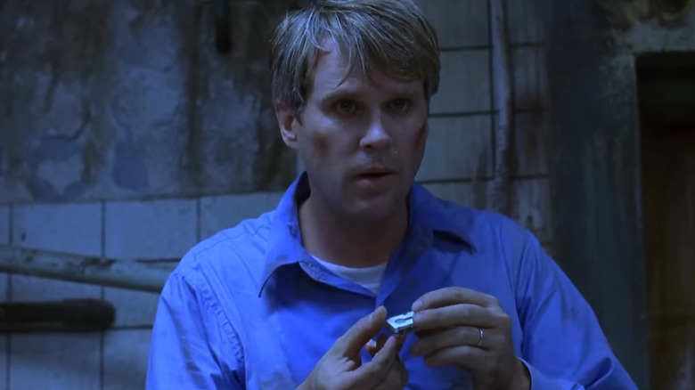 Cary Elwes as Dr. Gordon in Saw, holding a small tape