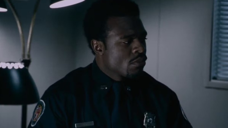 Lyriq Bent as Daniel Rigg sitting in a police office in Saw 6