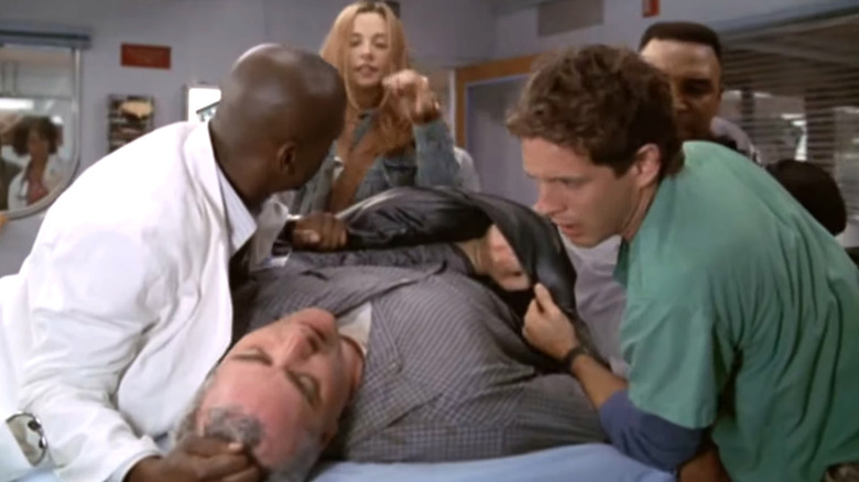 ER, Dr. Cooper helping to restrain a belligerent patient