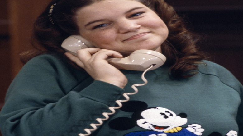 Mindy Cohn as Natalie Green, smiling on a phone call on "The Facts of Life"