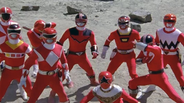 A group of Red Rangers stare concerned at the distance in Power Rangers Wild Force