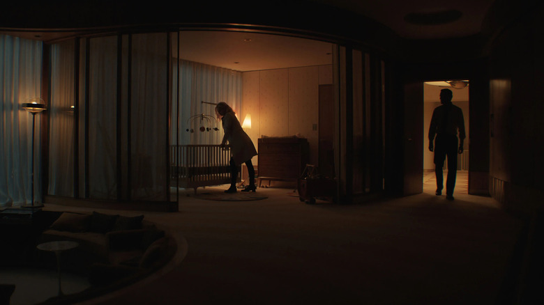 Sue Storm looks over a bed in a dark nursery with the next reeds in the door in Fantastic Four: The first steps