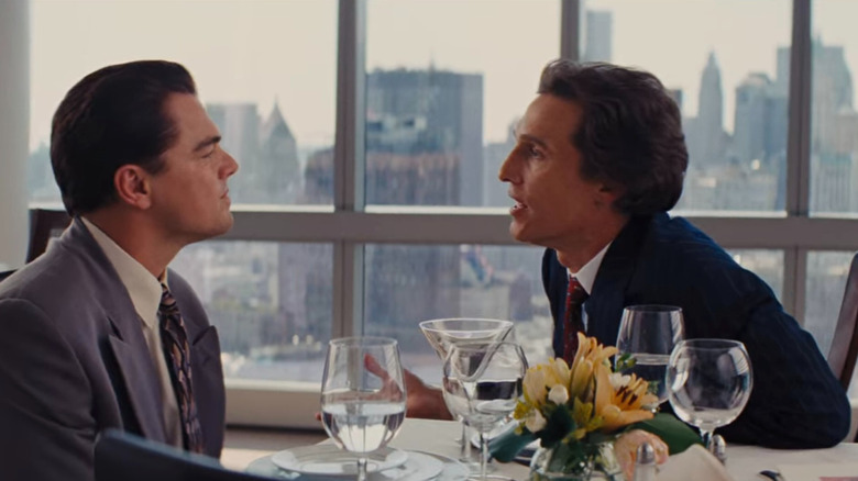 Jordan Belfort and Mark Hanna sitting at table