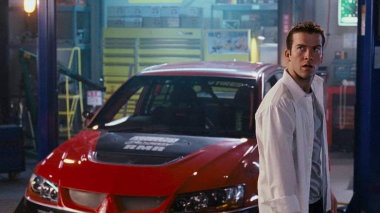 Sean in front of a red car in The Fast and the Furious: Tokyo Drift