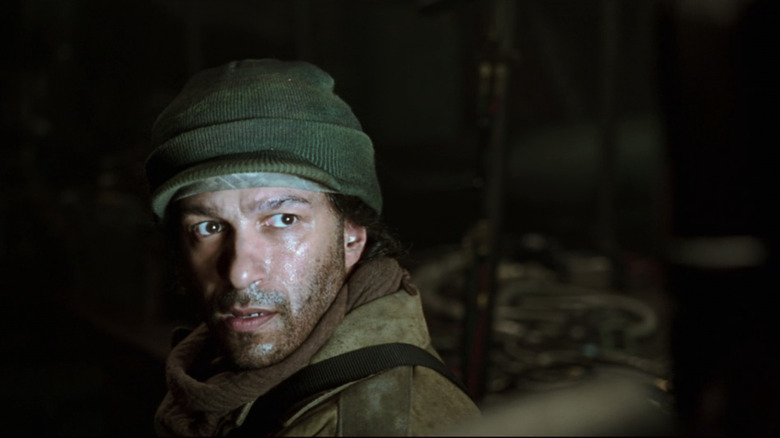 Tom Morillo as a terrorist looks up while his face shines with white light in the iron man