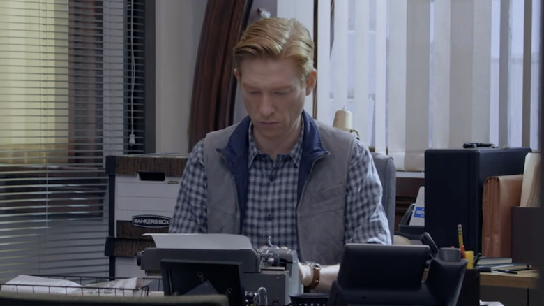 Ned sitting at a typewriter in his office on The Paper