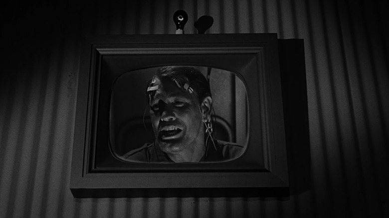 Mike Ferris in a test room, seen on a TV screen, looking terrified with wires on his head in The Twilight Zone