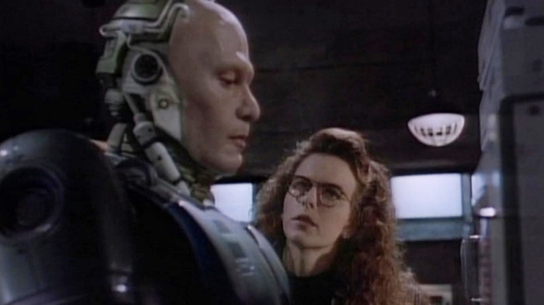 RoboCop with his helmet off next to Lisa in RoboCop (1994)
