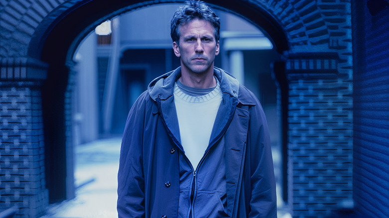 Ezekiel Stone standing in front of a blue entranceway on "Brimstone"