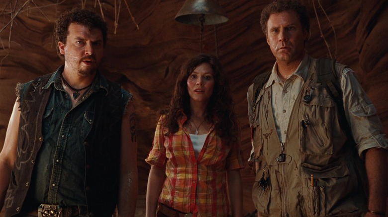 Will, Holly, and Rick, standing in a cave in Land of the Lost. A bell is above Holly's head.