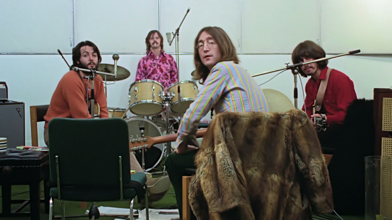 John Lennon, Paul McCartney, Ringo Starr, and George Harrison sitting in the studio in The Beatles: Get Back