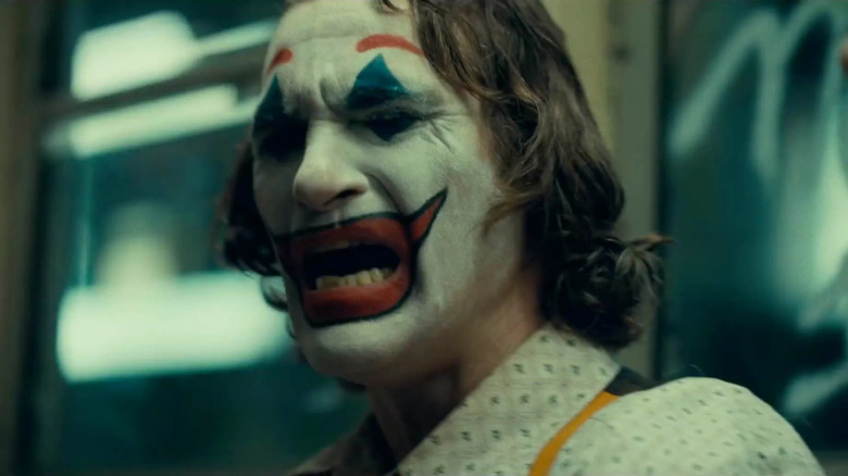Close-up of Joaquin Phoenix as Arthur Fleck/Joker crying and wearing the white, red and blue clown makeup in Joker