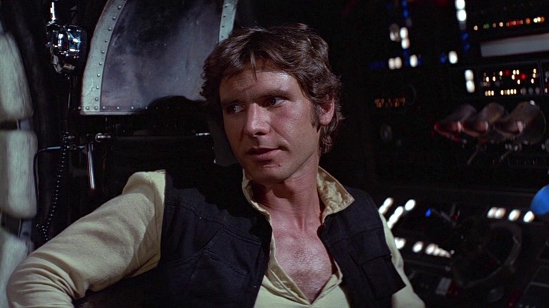 Harrison Ford como Han Solo sentado na Millennium Falcon em Star Wars: Uma Nova Esperança