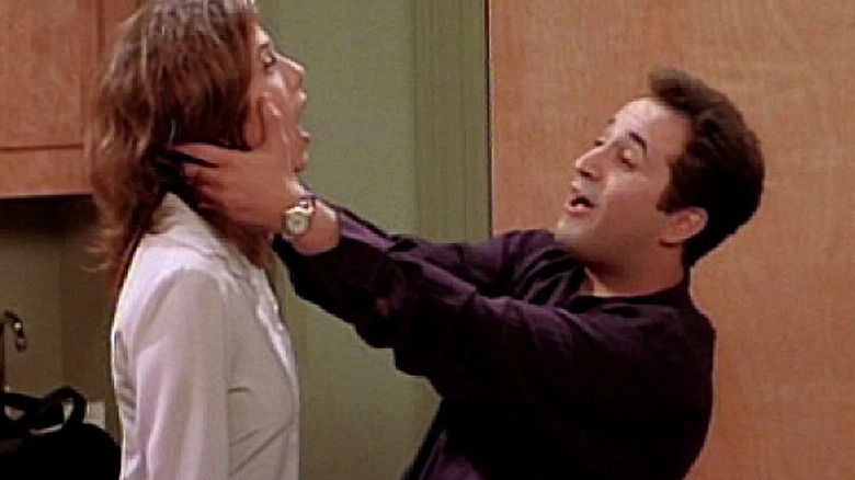 Dr. Barry Farber (Mitchell Whitfield) holds Rachel Green (Jennifer Aniston) by her face in his dentist office in "Friends"