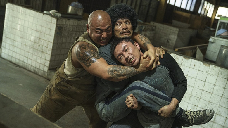 Wang Wei and his assailant are both being simultaneously choked by a large man in The Furious