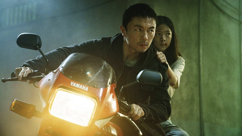 Wang Wei drives a motorcycle with his daughter riding behind him in The Furious