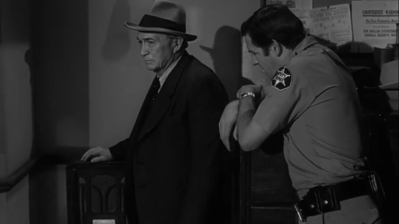Michael Constantine's Sheriff Charlie Koch stands alongside Paul Fix's Colby as they listen to the radio in The Twilight Zone