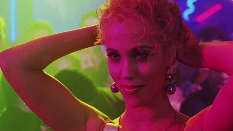 Elizabeth Berkley smiling, pulling hair back