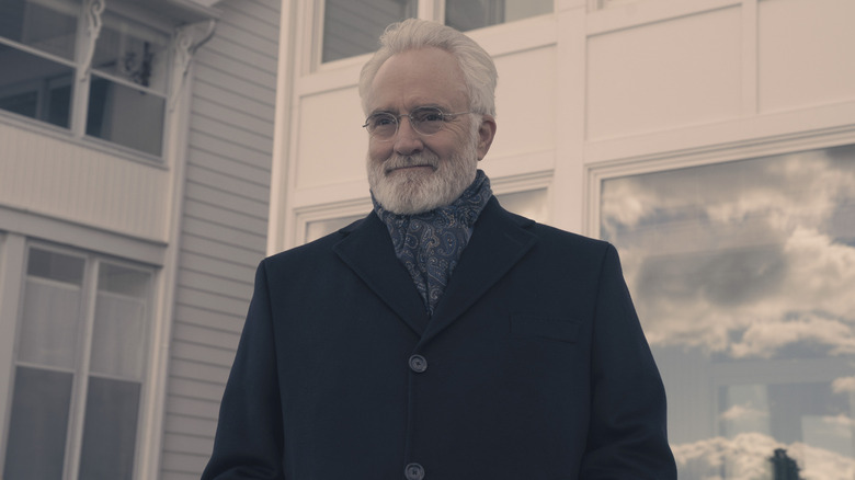 Commander Lawrence (Bradley Whitford) smiles while wearing an overcoat in The Handmaid's Tale