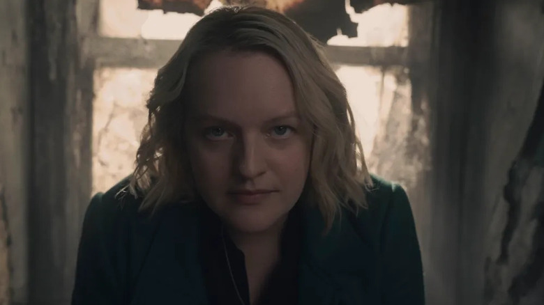 June (Elisabeth Moss), wearing a winter coat, stares directly into the camera with a serious and determined expression in The Handmaid's Tale
