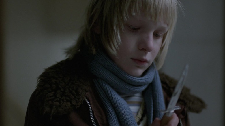 Oskar looking at a knife in Let the Right One In
