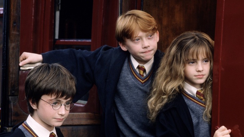 Harry, Ron, and Hermione boarding a train in Harry Potter and the Sorcerer's Stone