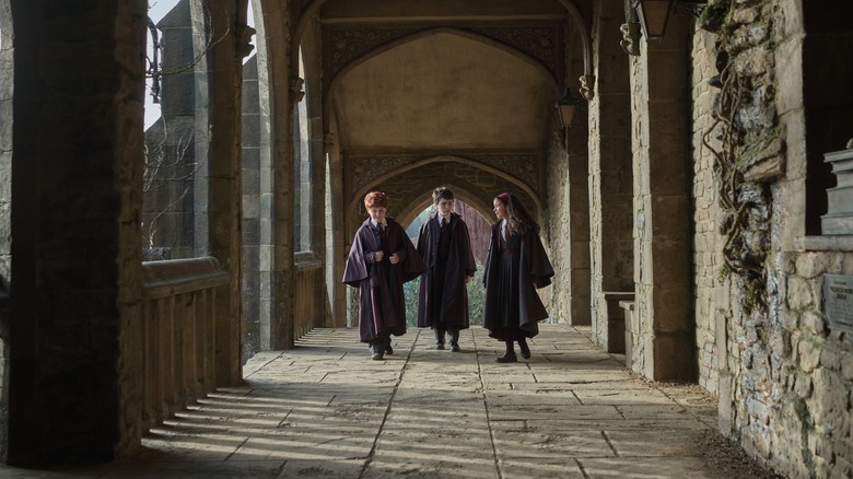Ron, Harry et Hermione marchant dans un couloir dans Harry Potter à l'école des sorciers