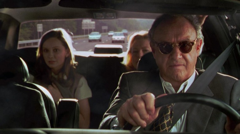 Gene Hackman como senador Keeley dirigindo com raiva seu carro na gaiola