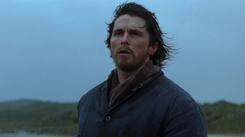 Christian Bale's Bruce Wayne stands in a remote landscape in Batman Begins.jpg