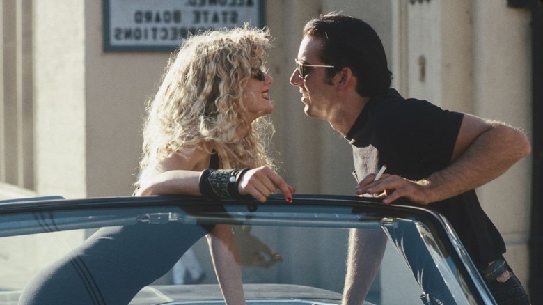 Lula in a car, with Sailor leaning over to kiss her in Wild at Heart