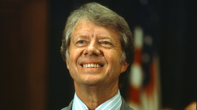 Jimmy Carter is in a suit and smiling