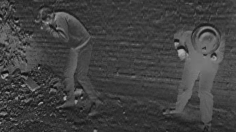 Two figures hunch over as a nuclear blast hits in The War Game