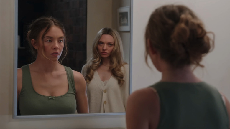 Millie (Sydney Sweeney) sees Nina (Amanda Seyfried) in a reflection in the bathroom mirror in The Housemaid