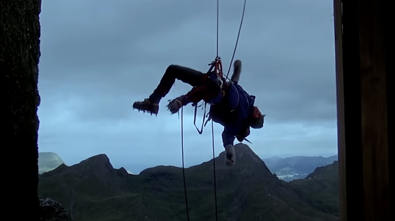 Clint Eastwood's Jonathan Hemlock hangs from a mountain via a safety rope in The Eiger Sanction
