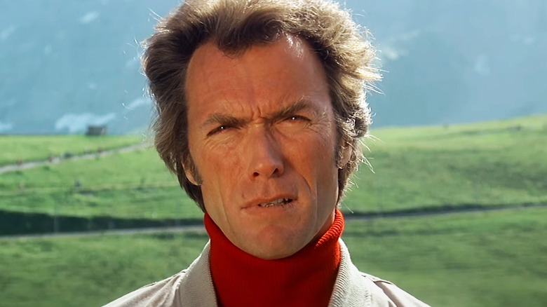 Clint Eastwood's Jonathan Hemlock is seen in closeup while standing in front of a field in The Eiger Sanction