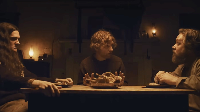 Daniel (Domhnall Gleeson) talks to Isla (Gayle Rankin) and Sandy (Grant O'Rourke) at a dinner table in The Incomer