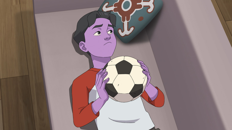 Oliver lying on the sofa playing with an invincible football ball