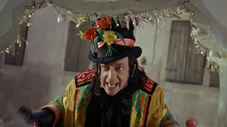 Child Catcher standing outside of a doorway in "Chitty Chitty Bang Bang"