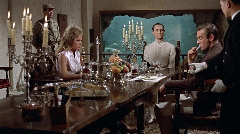 James Bond, sitting at a fancy dinner table with a pretty woman and Dr. No in Dr. No